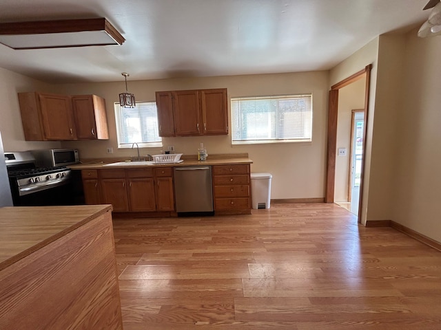 23851 Annapolis St, Dearborn Heights, MI 48125 - kitchen featuring appliances with stainless steel finishes, a sink, light wood-type flooring, and pendant lighting