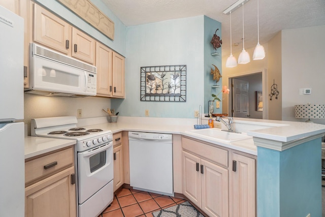 kitchen with white appliances, a peninsula, light brown cabinets, a sink, and light tile patterned floors