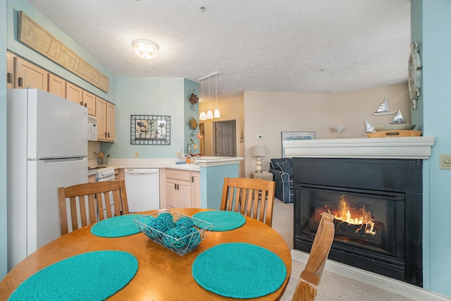 dining space with a lit fireplace and a textured ceiling