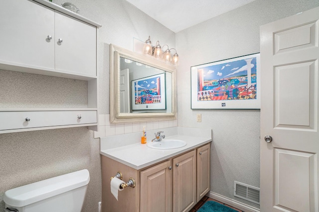 bathroom featuring vanity and toilet