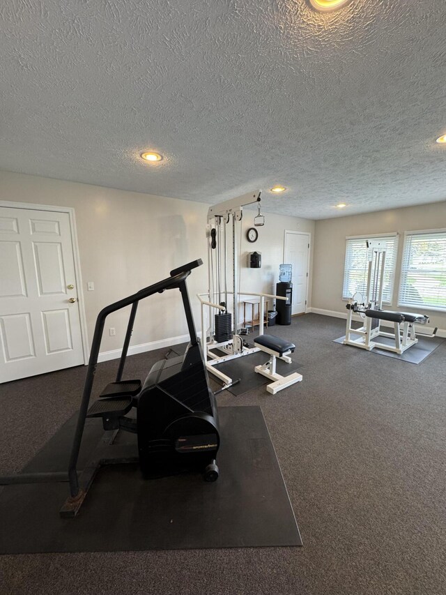 exercise room featuring carpet, baseboards, recessed lighting, and a textured ceiling