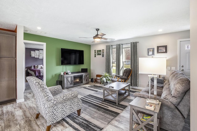 554 Ottawa Trl, Buckley, MI 49620 - living room with a ceiling fan, light wood-type flooring, recessed lighting, a fireplace, and baseboards