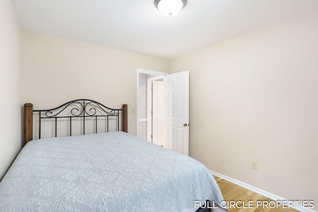 bedroom featuring wood finished floors and baseboards