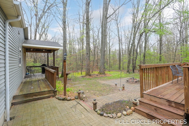 view of yard with a wooden deck and a patio
