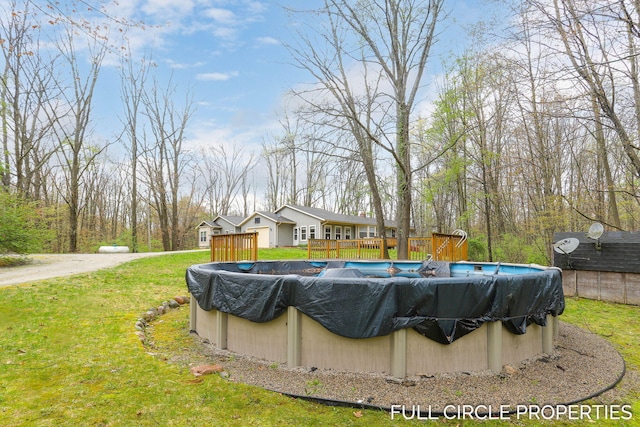 view of pool featuring a wooden deck, a covered pool, and a lawn