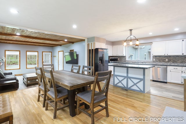 dining room featuring light wood-style flooring, plenty of natural light, beamed ceiling, and recessed lighting