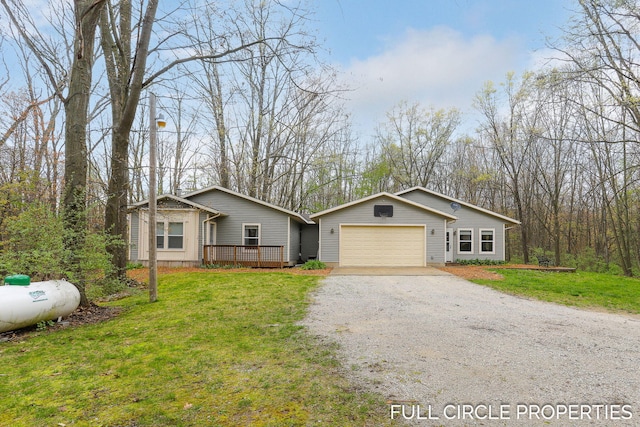 view of front of home featuring driveway, a garage, a front lawn, and a wooden deck