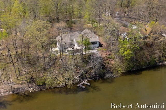 view from above of property featuring a heavily wooded area and a large body of water