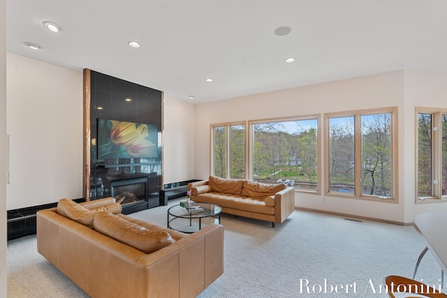 living area with carpet flooring, a tile fireplace, recessed lighting, and baseboards