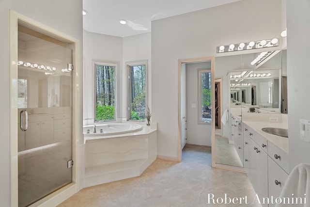 full bathroom with a garden tub, vanity, a stall shower, and baseboards