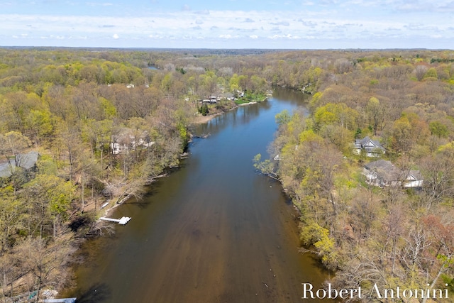 aerial overview of property's location featuring a heavily wooded area and a nearby body of water