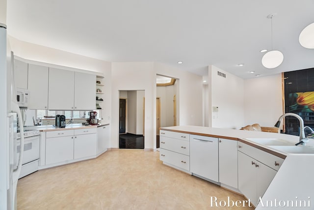 kitchen with white appliances, a sink, light countertops, white cabinetry, and recessed lighting