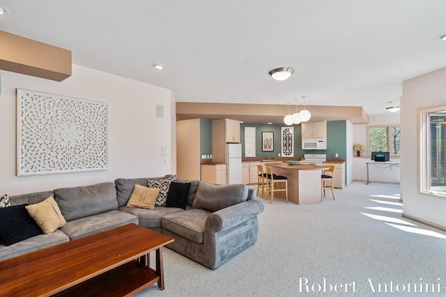 living area featuring light carpet and recessed lighting