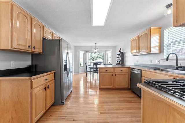 24231 Wilson Dr, Trenton, MI 48183 - kitchen with a sink, appliances with stainless steel finishes, a peninsula, light wood-type flooring, and light brown cabinets
