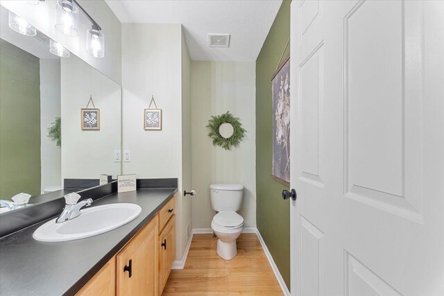 24231 Wilson Dr, Trenton, MI 48183 - bathroom featuring toilet, baseboards, wood finished floors, and vanity