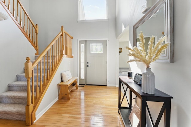24231 Wilson Dr, Trenton, MI 48183 - foyer featuring a towering ceiling, light wood finished floors, stairway, and baseboards