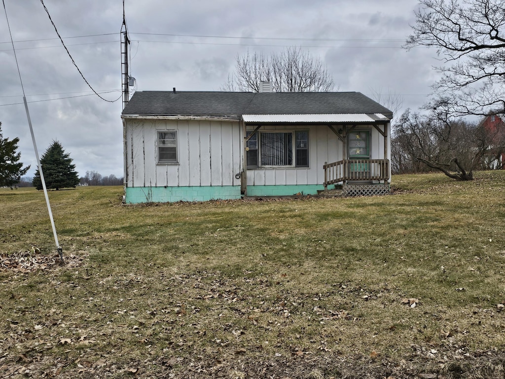 66660 Territorial Rd, Lawrence, MI 49064 - view of front of home featuring board and batten siding, a porch, a front yard, and a chimney
