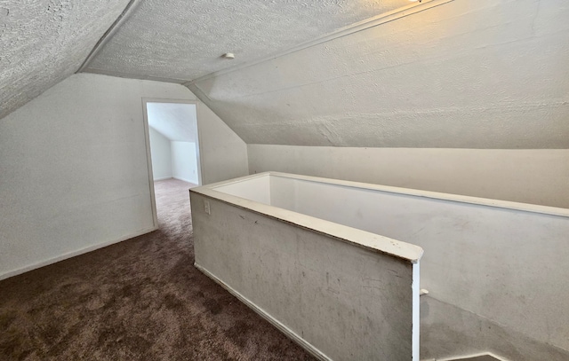 bonus room featuring lofted ceiling, carpet, a textured ceiling, and baseboards