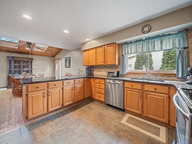 4825 Downing Dr, Pinckney, MI 48169 - kitchen featuring stainless steel appliances, a sink, a skylight, a peninsula, and dark stone counters
