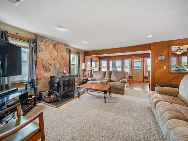 4825 Downing Dr, Pinckney, MI 48169 - living room featuring a wood stove, carpet flooring, and wooden walls