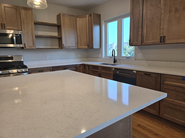 319 Sedgewood Ln, Ann Arbor, MI 48103 - kitchen with stainless steel appliances, a sink, open shelves, dark wood-style floors, and light stone counters