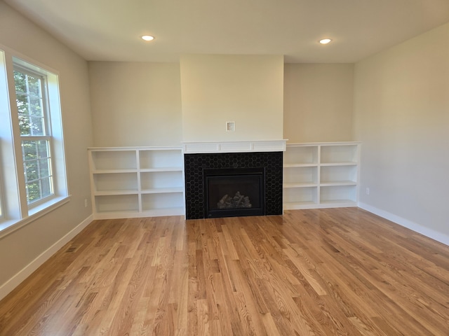 319 Sedgewood Ln, Ann Arbor, MI 48103 - unfurnished living room with wood finished floors, a tile fireplace, baseboards, and recessed lighting