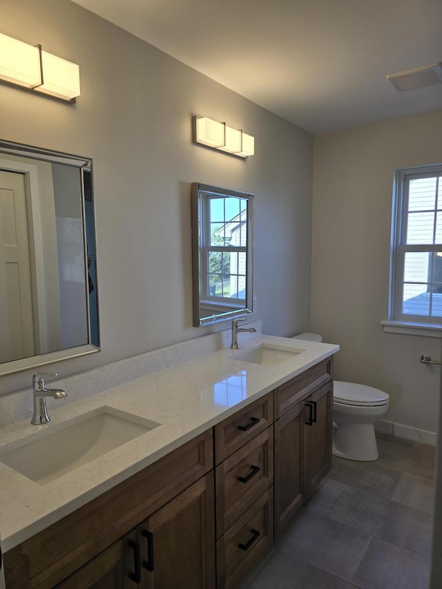 319 Sedgewood Ln, Ann Arbor, MI 48103 - bathroom featuring toilet, double vanity, and baseboards
