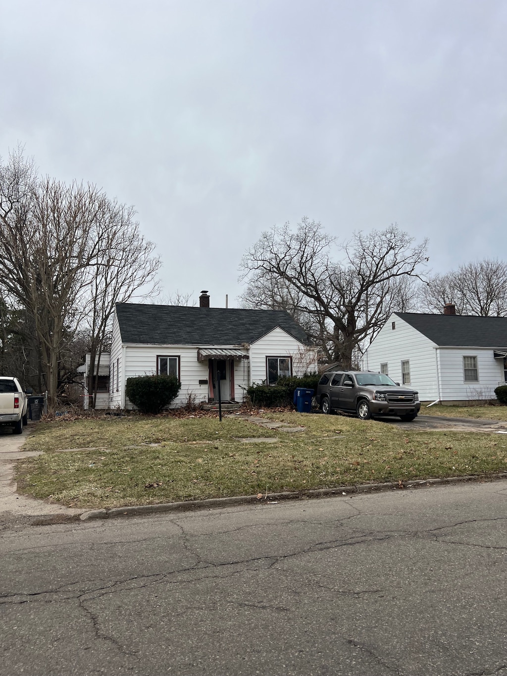 2631 Brownell Blvd, Flint, MI 48504 - view of front of property with a front yard, a chimney, and driveway