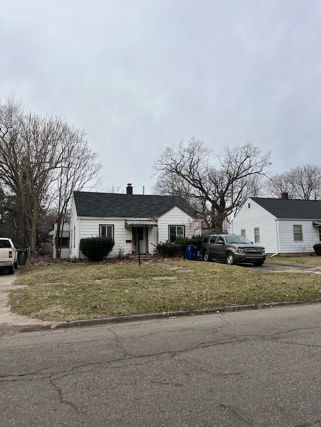2631 Brownell Blvd, Flint, MI 48504 - view of front of property with a front yard, a chimney, and driveway