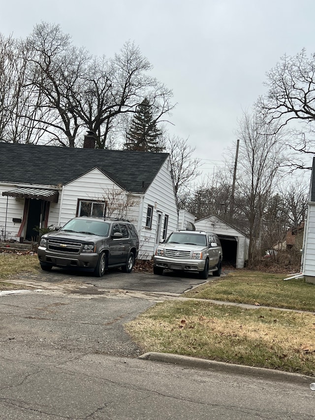 2631 Brownell Blvd, Flint, MI 48504 - view of front of property featuring asphalt driveway, a chimney, a shingled roof, and a front yard