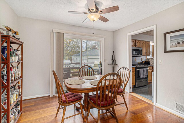 2682 Pinehurst Rd, Norton Shores, MI 49441 - dining space featuring a ceiling fan, light wood-style flooring, a textured ceiling, and baseboards