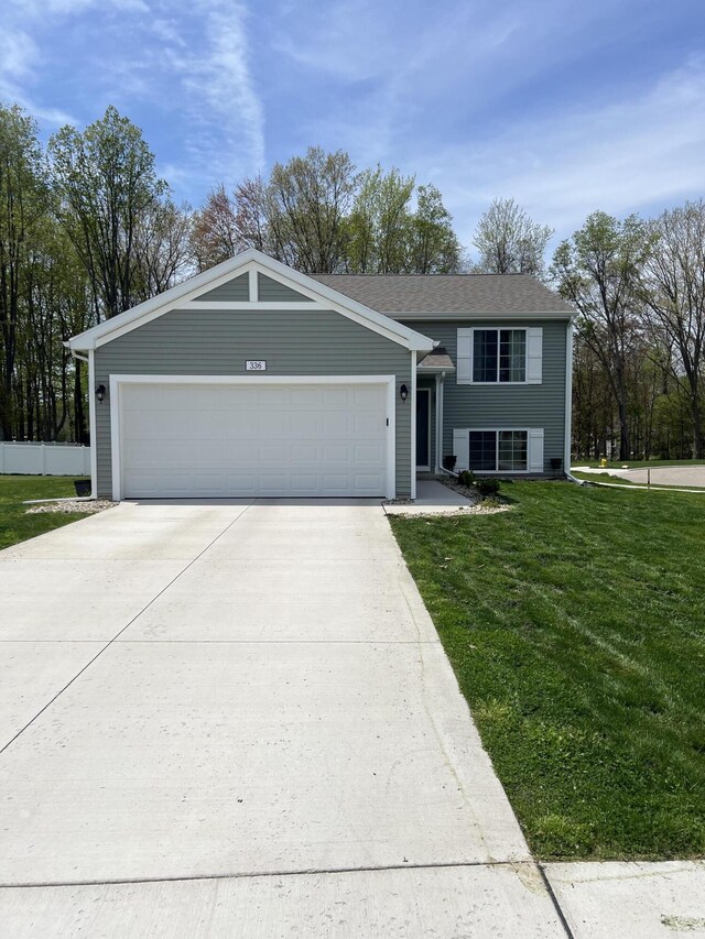 view of front of house with a front lawn, driveway, and an attached garage