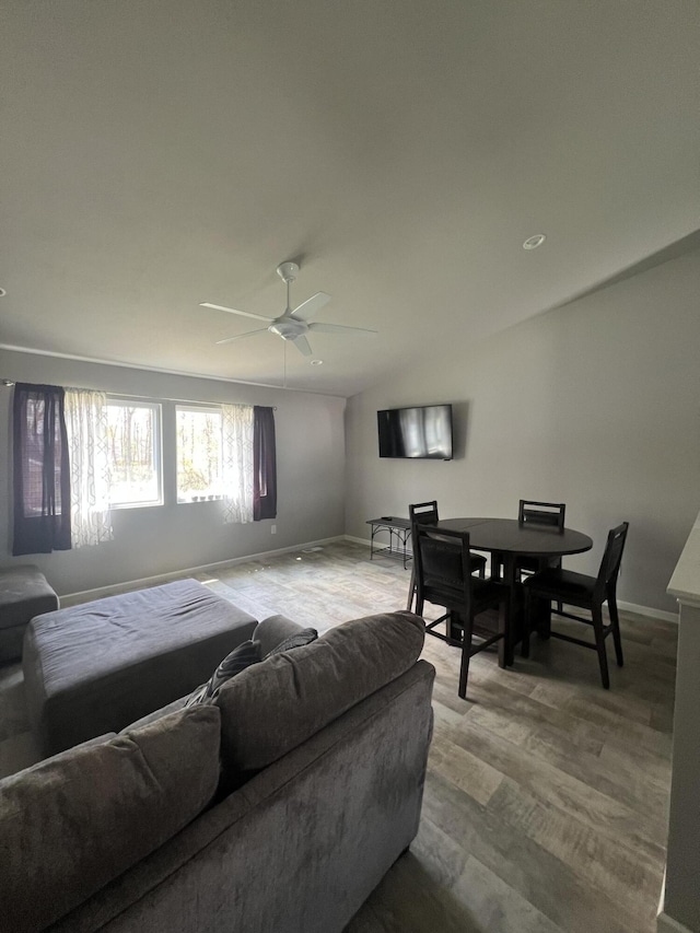 living room featuring baseboards, a ceiling fan, and wood finished floors