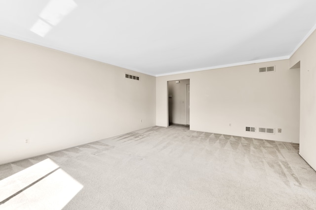 spare room with light carpet and crown molding