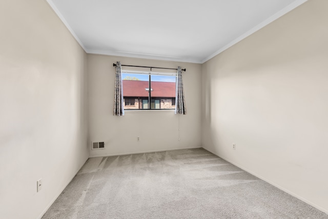 empty room with crown molding, carpet floors, and baseboards