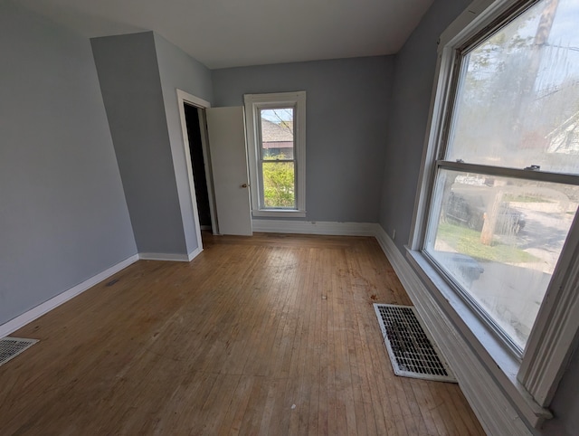 unfurnished room featuring baseboards and hardwood / wood-style floors