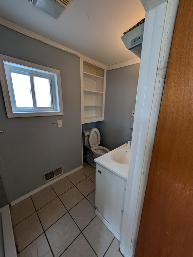 bathroom with vanity, tile patterned floors, baseboards, and toilet