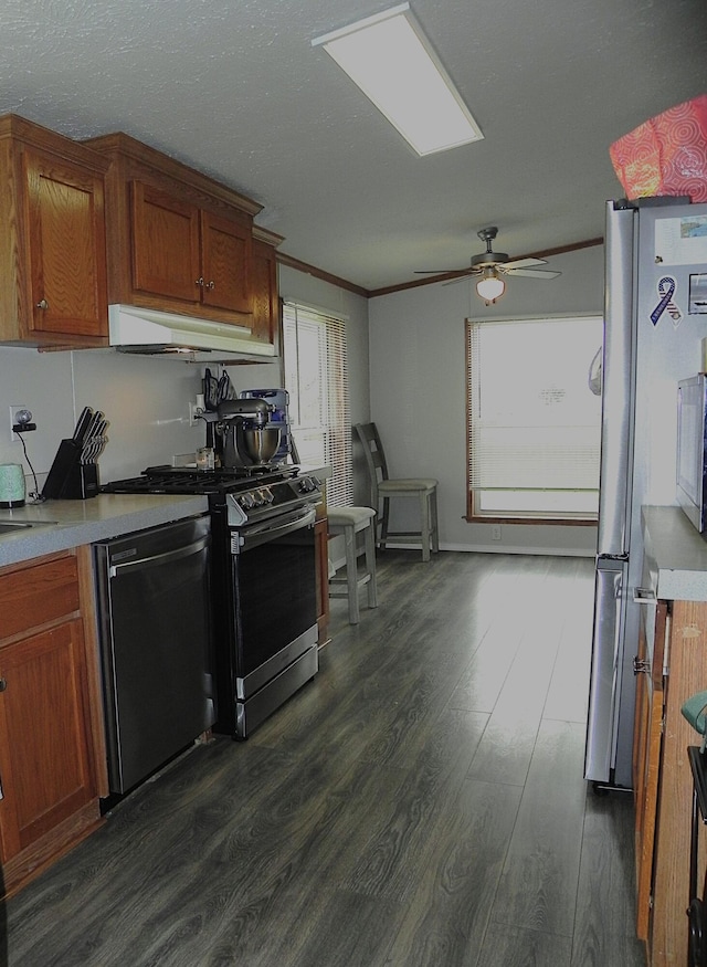 1232 Shiawassee River Rd, Three Rivers, MI 49093 - kitchen featuring stainless steel appliances, dark wood-style flooring, crown molding, light countertops, and under cabinet range hood