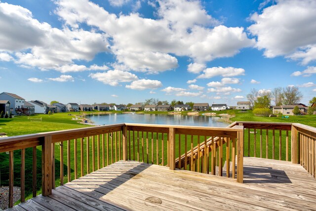 deck featuring a residential view, a water view, and a lawn
