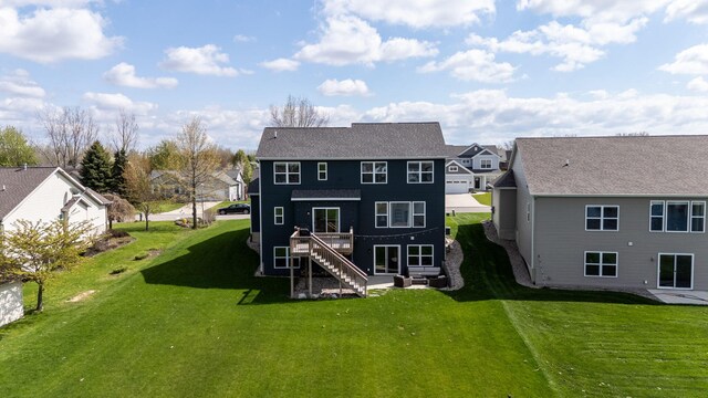 rear view of property with a residential view, stairway, and a lawn