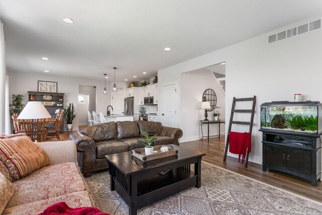 living area featuring wood finished floors, recessed lighting, and baseboards