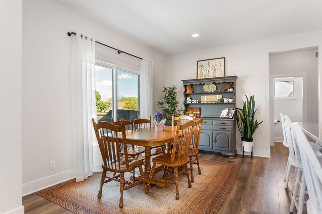 dining room featuring baseboards, wood finished floors, and recessed lighting
