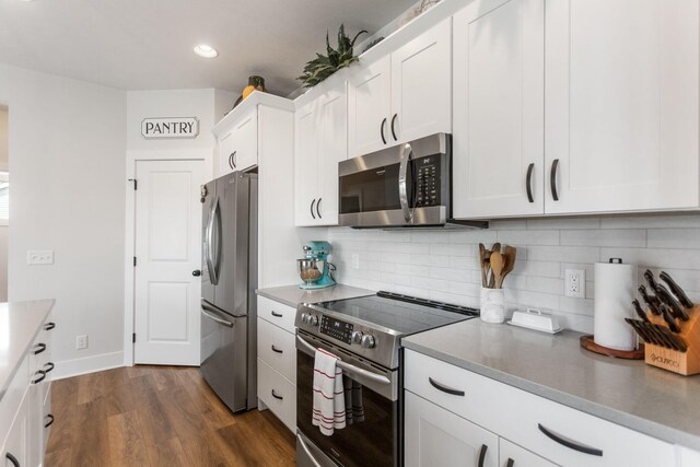 kitchen with stainless steel appliances, white cabinets, backsplash, dark wood-type flooring, and recessed lighting