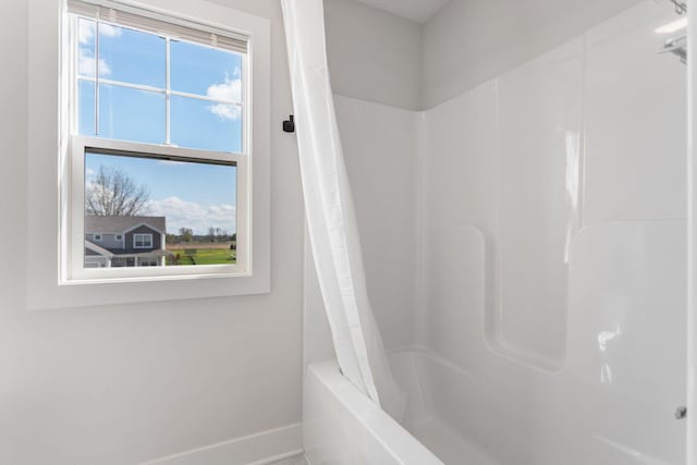 full bath with baseboards and shower / tub combo