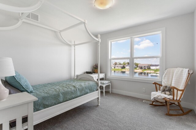 carpeted bedroom with a water view and baseboards