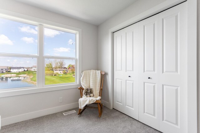 living area with light carpet and baseboards