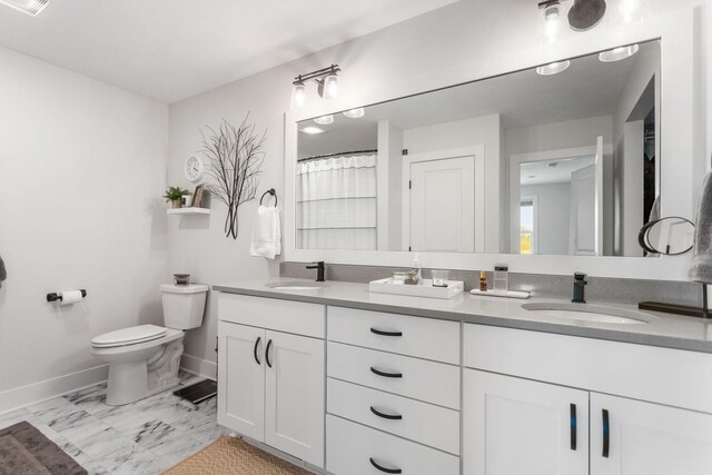 full bathroom featuring baseboards, toilet, double vanity, and marble look tiles