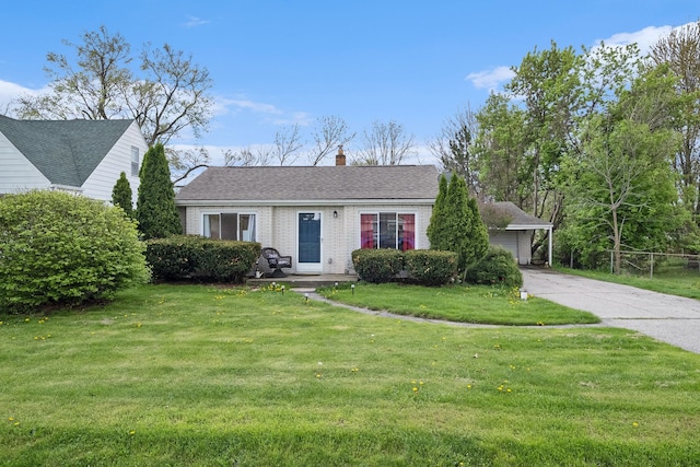 view of front of property with a front lawn, a chimney, brick siding, and a garage
