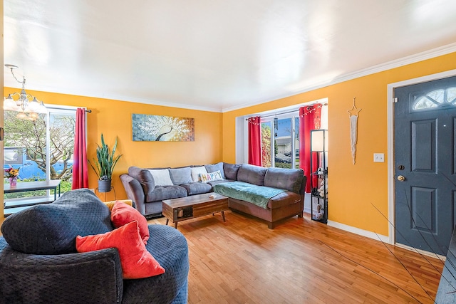 living area with light wood-style floors, plenty of natural light, crown molding, and baseboards