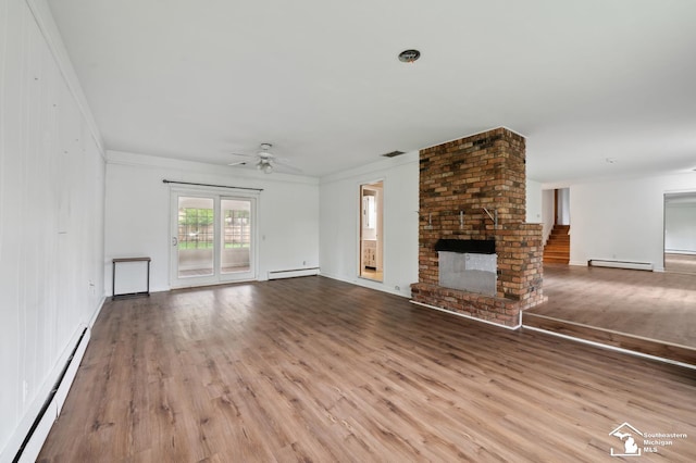 unfurnished living room with a baseboard heating unit, wood finished floors, a ceiling fan, and ornamental molding